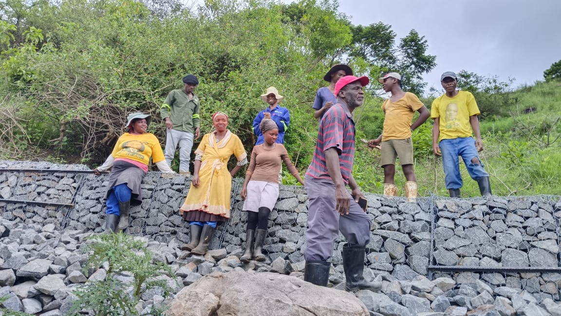 Group of people sitting on a gabion wall