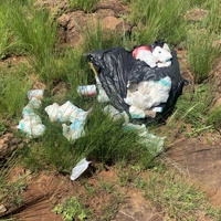 Disposable nappy waste spilling out of black bin bag