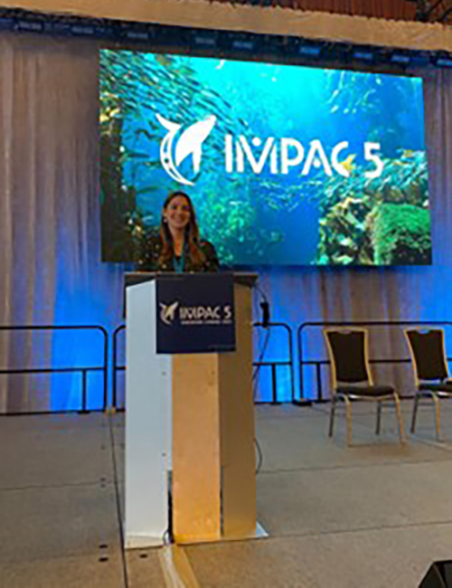 Photograph of JNCC staff member Gemma Singleton at the IMPAC4 conference. Gemma is standing at a podium giving a presentation, with a screen behind her displaying a presentation. This image is decorative and is not referred to on the webpage.
