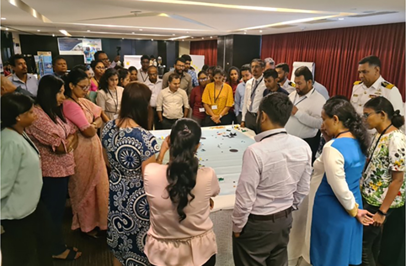 Photograph showing participants standing around a table at an Emergency Response Preparedness Workshop, held in Sri Lanka.
